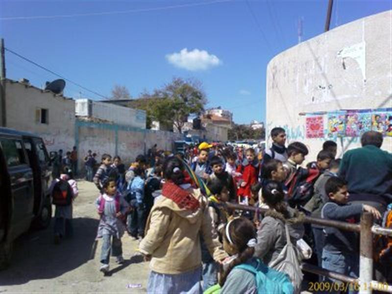 A UNWRA refugee school at home time, school bus in foreground Sc